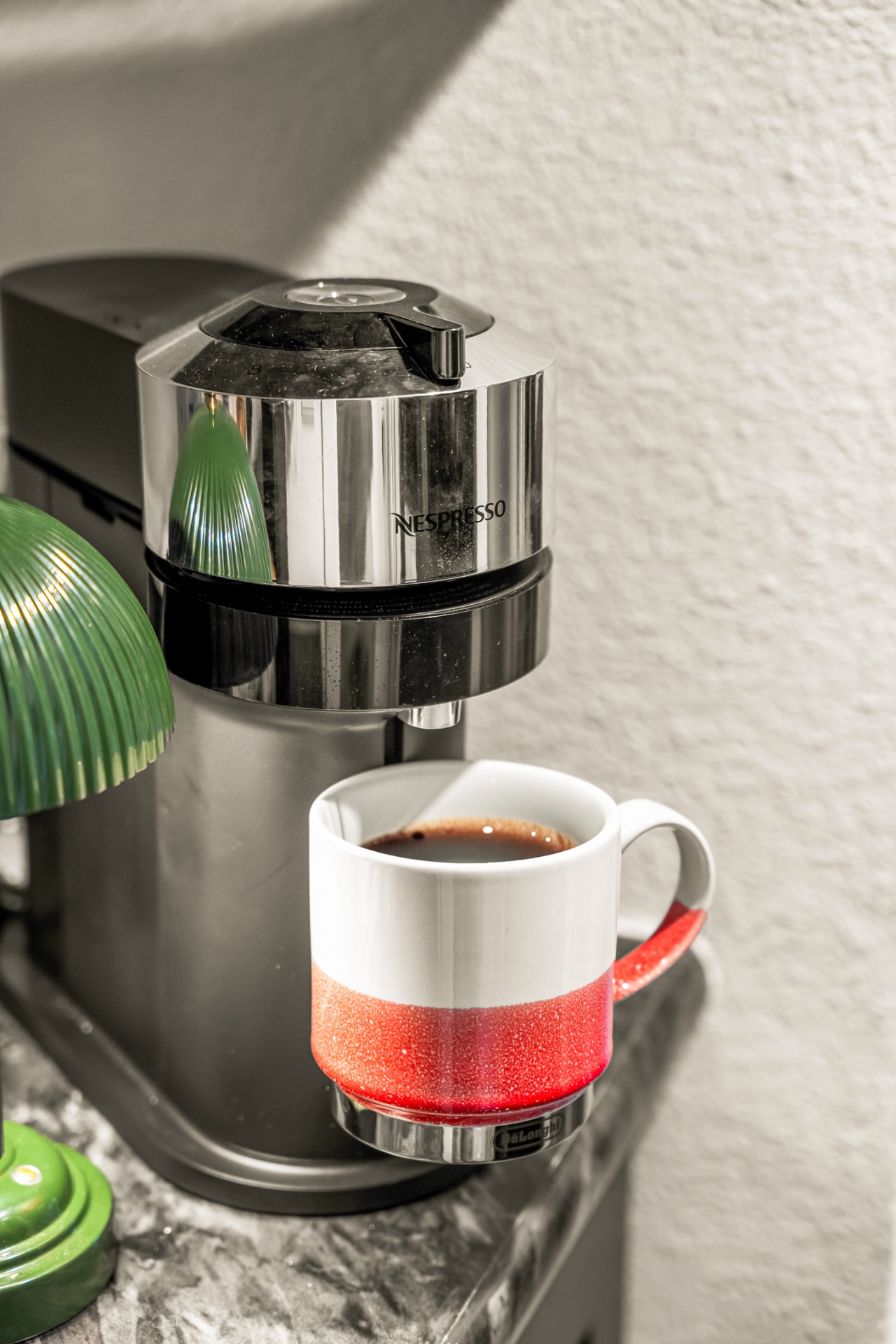 Nespresso machine beside a fresh cup of coffee