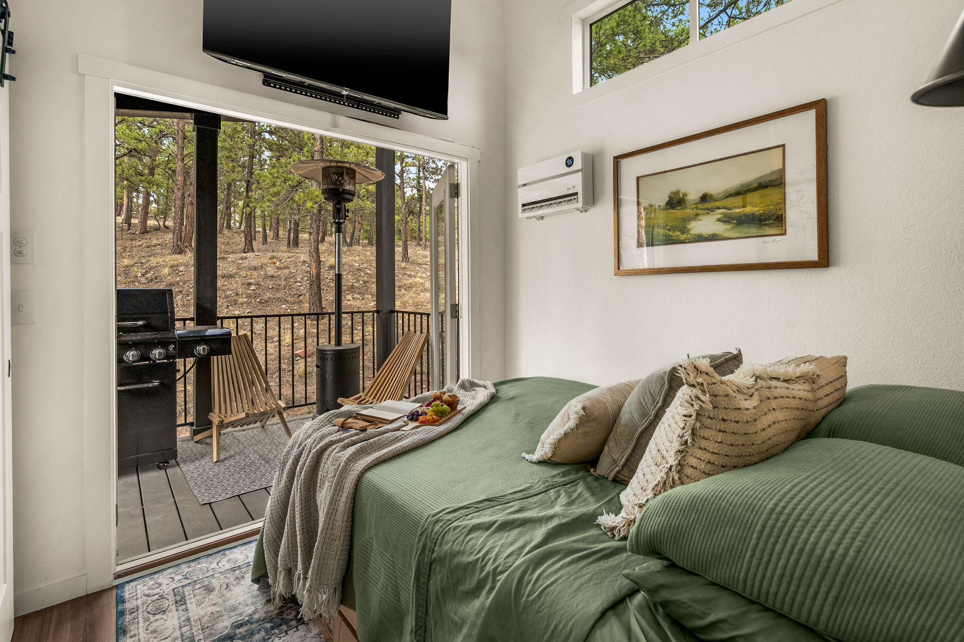 Bedroom with sliding doors open to a private deck in the pines