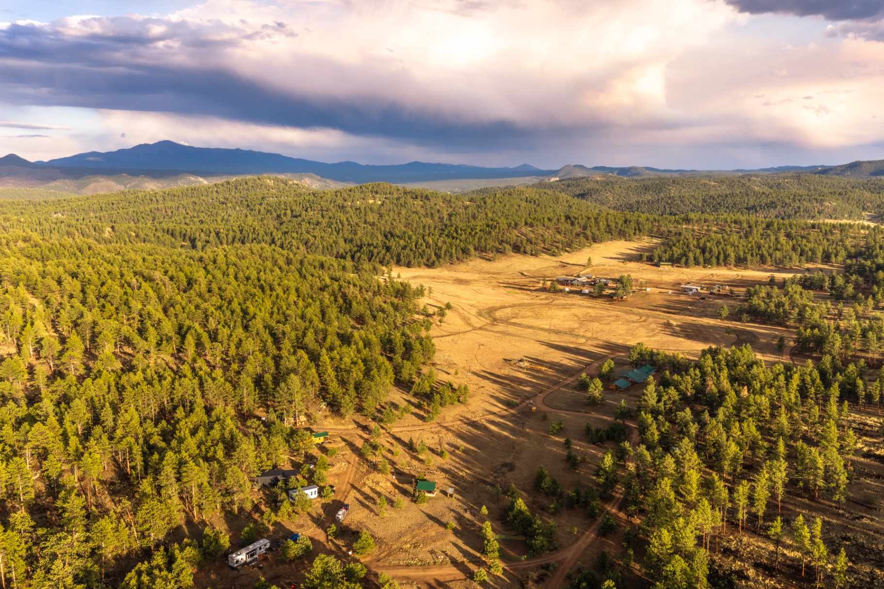 Wide aerial view of M Lazy C Ranch tucked into the pines and foothills